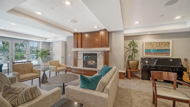 living room featuring a raised ceiling and light colored carpet