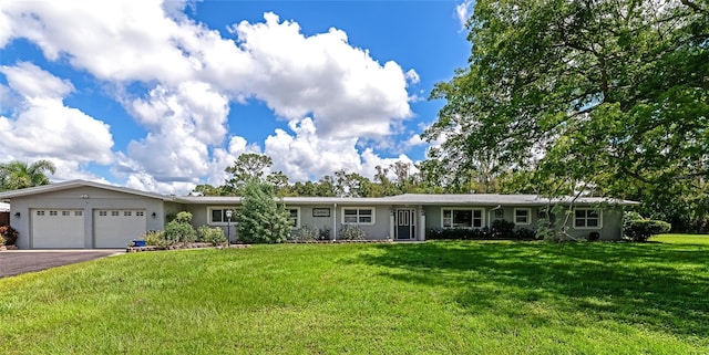 single story home featuring a garage, driveway, and a front lawn