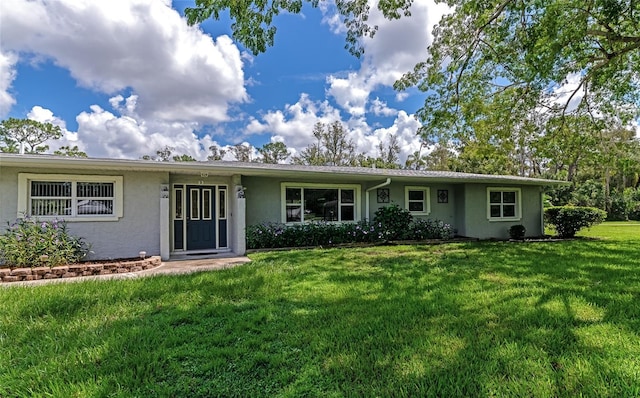 ranch-style home with a front yard and stucco siding