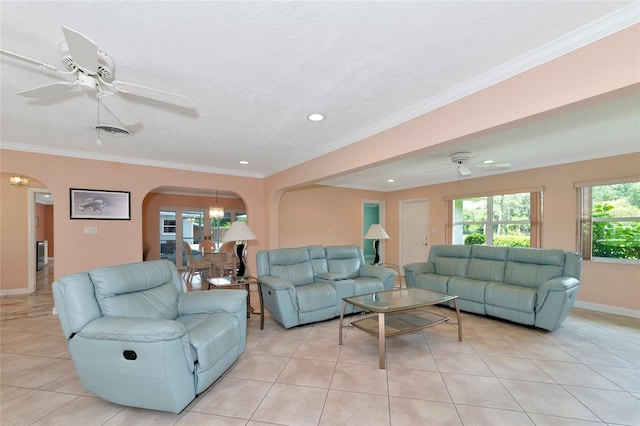 living area with arched walkways, ornamental molding, ceiling fan with notable chandelier, and visible vents