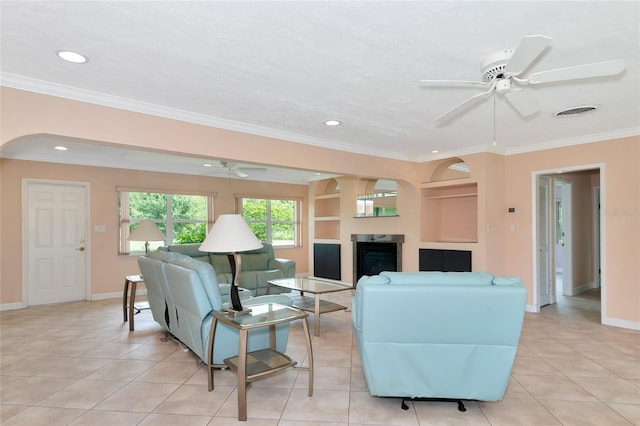 living area with light tile patterned floors, visible vents, ornamental molding, and a ceiling fan