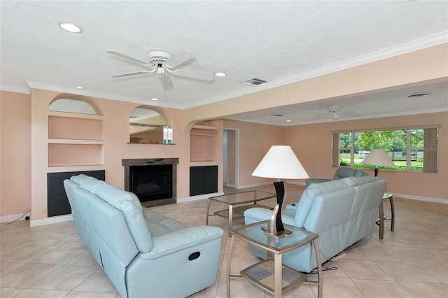 living room featuring a fireplace, a ceiling fan, visible vents, built in features, and crown molding