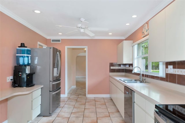 kitchen featuring appliances with stainless steel finishes, a sink, visible vents, and crown molding