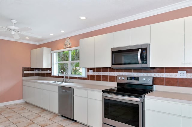 kitchen featuring stainless steel appliances, a sink, light countertops, backsplash, and crown molding