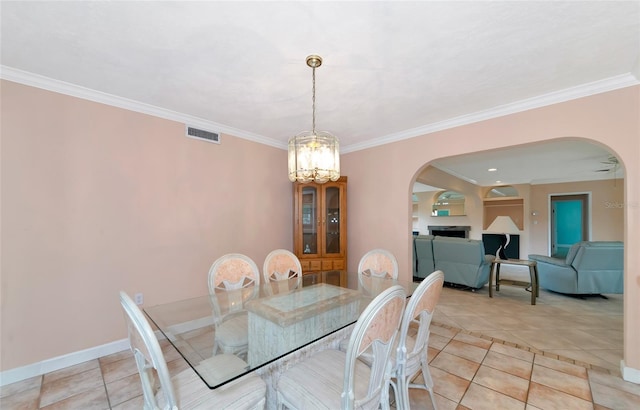 dining space featuring arched walkways, visible vents, a notable chandelier, and baseboards