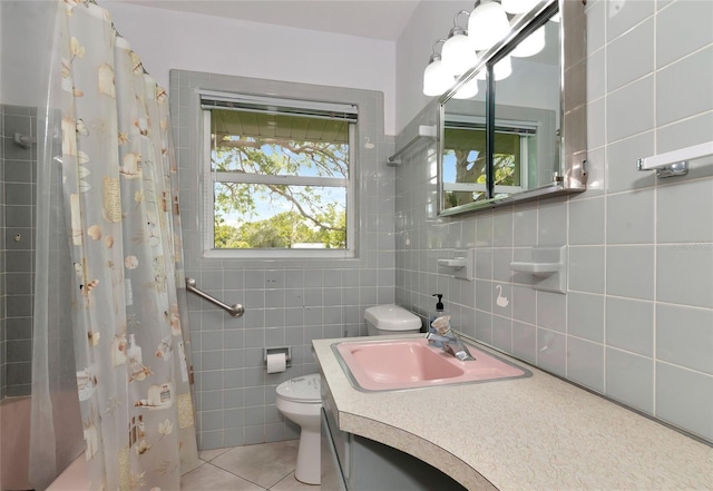 bathroom featuring tile patterned flooring, tile walls, toilet, and vanity