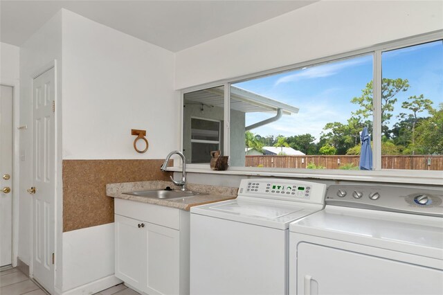 laundry room featuring cabinet space, washer and clothes dryer, and a sink