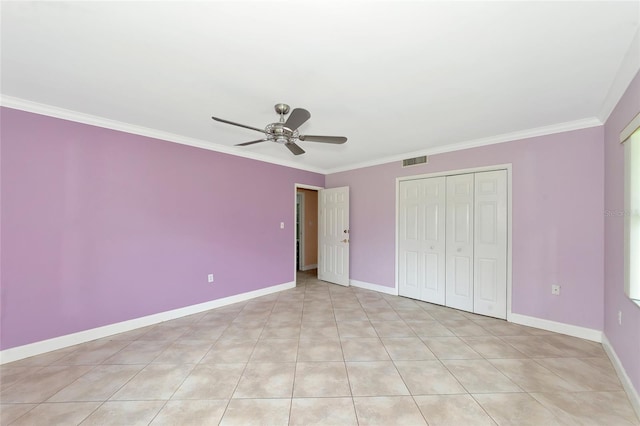 unfurnished bedroom featuring baseboards, visible vents, a ceiling fan, crown molding, and a closet