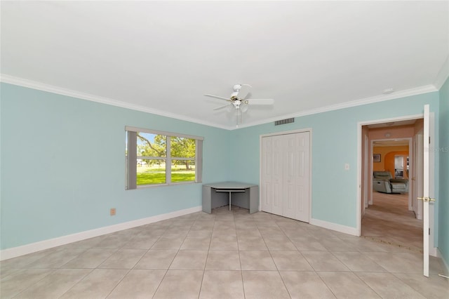 unfurnished bedroom with light tile patterned floors, visible vents, baseboards, crown molding, and a closet