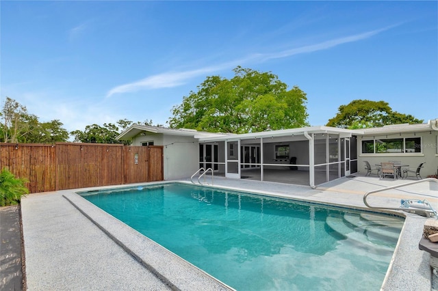 view of pool featuring a fenced in pool, a sunroom, fence, and a patio