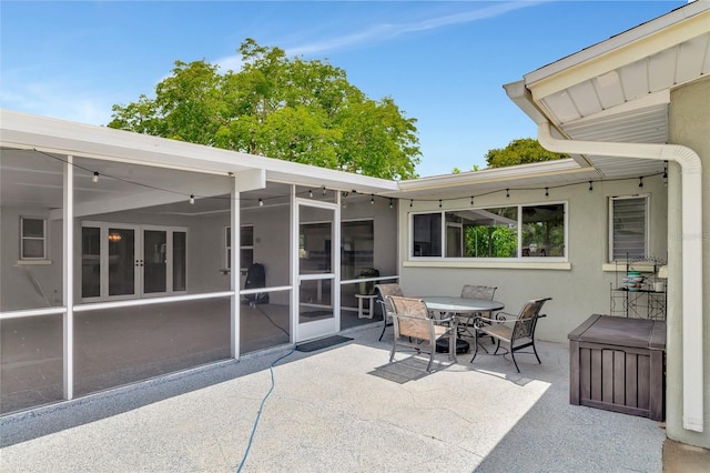 view of patio / terrace featuring a sunroom and outdoor dining space