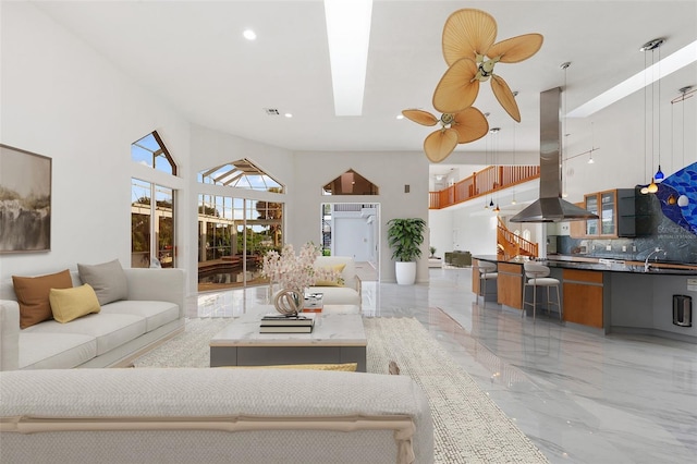 living room with a towering ceiling and a skylight