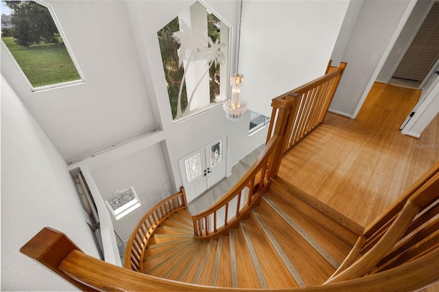 stairs featuring a high ceiling and hardwood / wood-style flooring