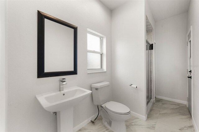 bathroom featuring toilet and a shower with shower door