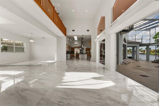 interior space featuring plenty of natural light and a towering ceiling