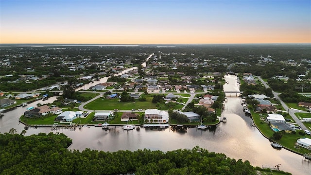 aerial view at dusk featuring a water view