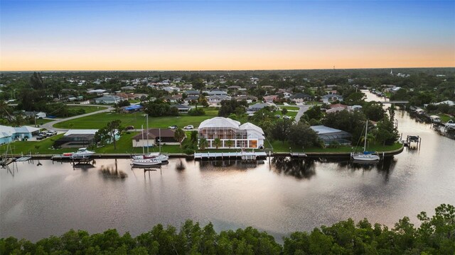 aerial view at dusk featuring a water view