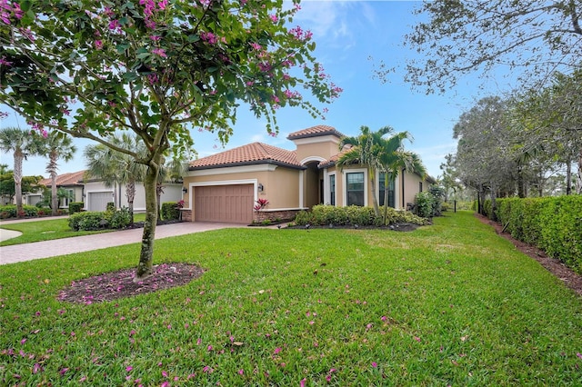 mediterranean / spanish house with a garage and a front yard