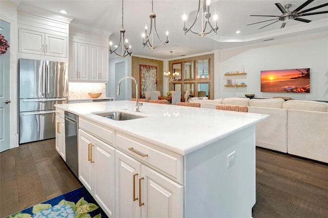 kitchen featuring ceiling fan with notable chandelier, stainless steel appliances, sink, an island with sink, and dark wood-type flooring