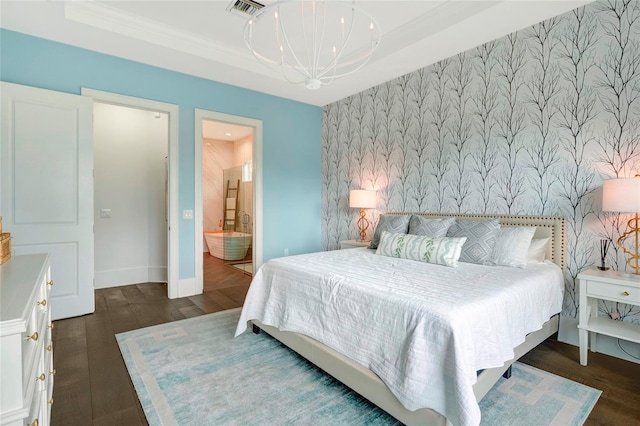 bedroom with an inviting chandelier, dark hardwood / wood-style flooring, ornamental molding, and ensuite bathroom