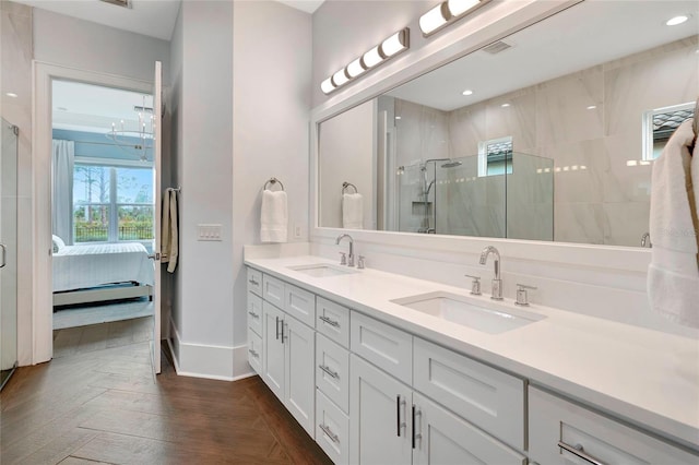 bathroom featuring hardwood / wood-style flooring, a tile shower, and vanity