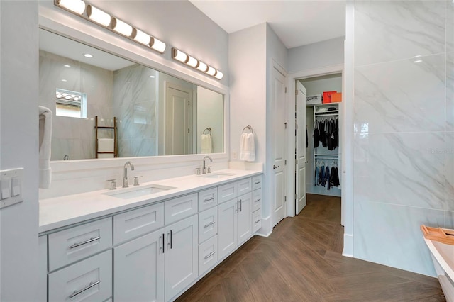 bathroom with parquet floors, vanity, and a shower