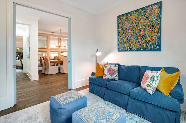 living room featuring ornamental molding, wood-type flooring, and a chandelier