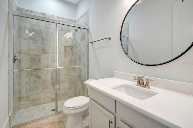 bathroom featuring vanity, toilet, and a shower with door