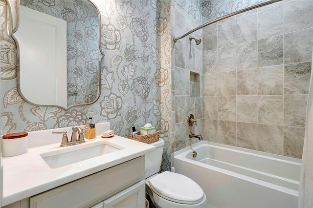 full bathroom featuring tiled shower / bath, toilet, and vanity