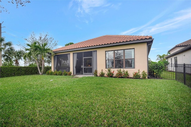 back of house featuring a lawn and a sunroom