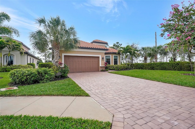 mediterranean / spanish-style house featuring a garage and a front yard