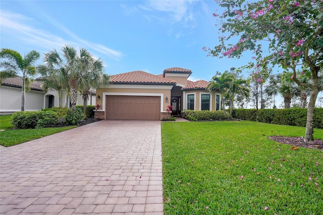 mediterranean / spanish house featuring a garage and a front lawn