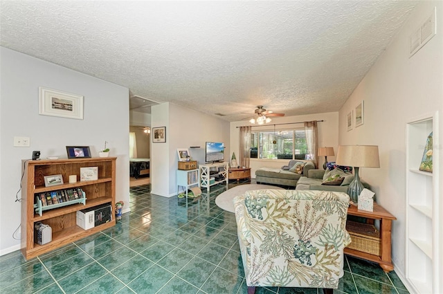 living room featuring dark tile patterned floors, visible vents, ceiling fan, and a textured ceiling