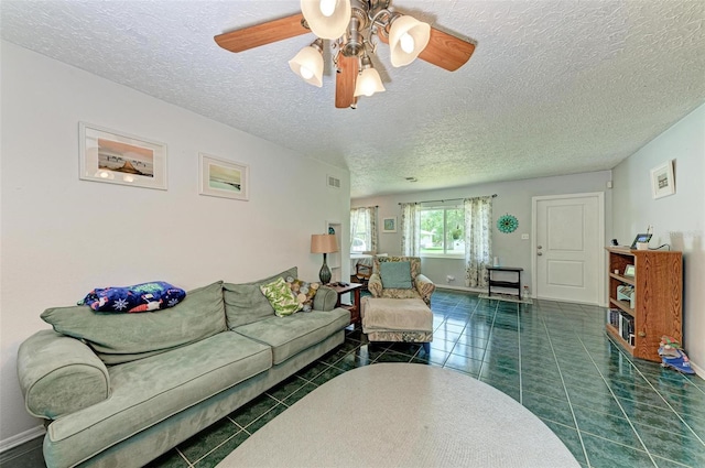 tiled living room with a ceiling fan, visible vents, baseboards, and a textured ceiling