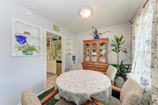 dining area featuring a textured ceiling and built in shelves