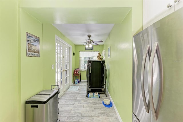 kitchen featuring baseboards, a ceiling fan, and freestanding refrigerator