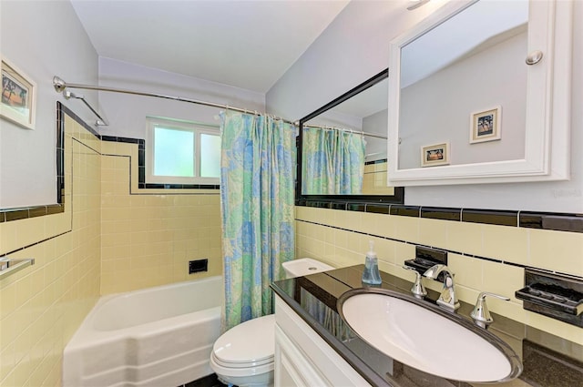 full bathroom with toilet, shower / bath combo, tile walls, and vanity