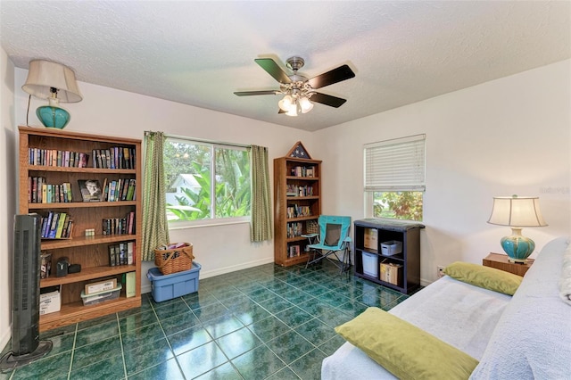 interior space featuring plenty of natural light, a textured ceiling, and baseboards