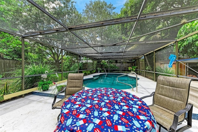 view of pool with a fenced in pool, glass enclosure, a patio area, and a fenced backyard