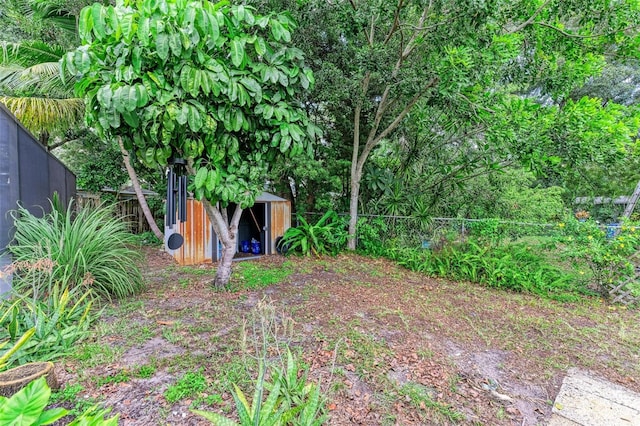 view of yard with a storage shed, an outbuilding, and a fenced backyard