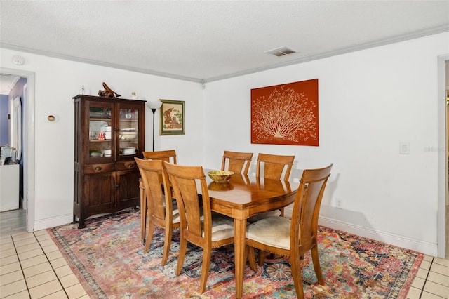 dining area with a textured ceiling and light tile patterned flooring