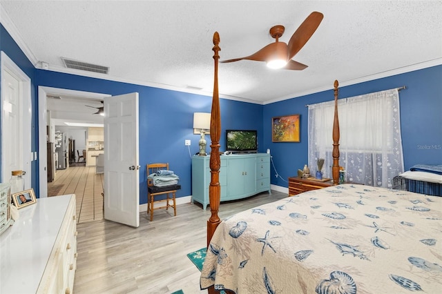 bedroom with a textured ceiling, ceiling fan, ornamental molding, and light hardwood / wood-style floors