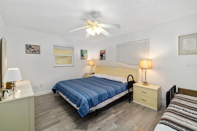 bedroom featuring a textured ceiling, wood-type flooring, and ceiling fan