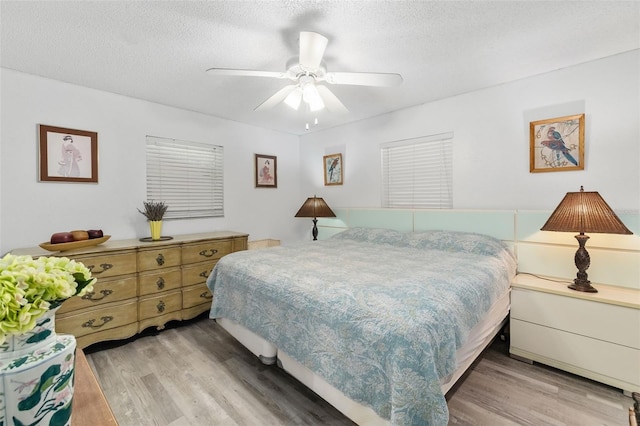 bedroom featuring a textured ceiling, ceiling fan, and light hardwood / wood-style floors