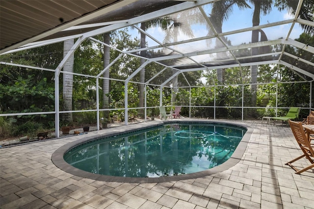 view of swimming pool with a patio area and a lanai