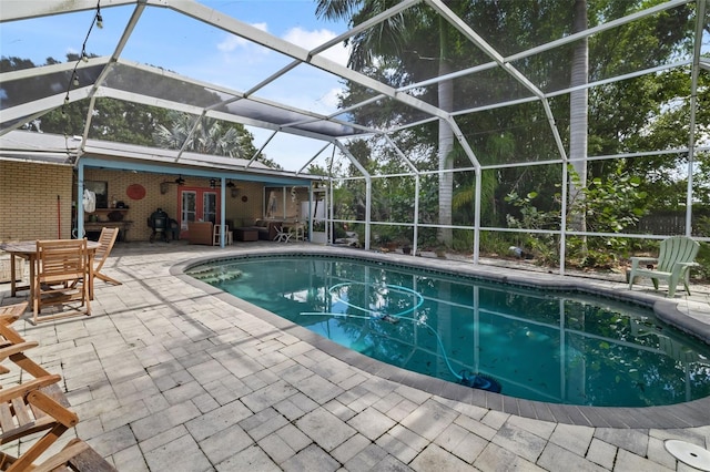 view of swimming pool featuring a patio and glass enclosure