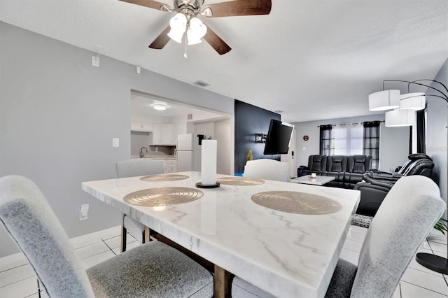 dining room with sink, light tile patterned floors, and ceiling fan