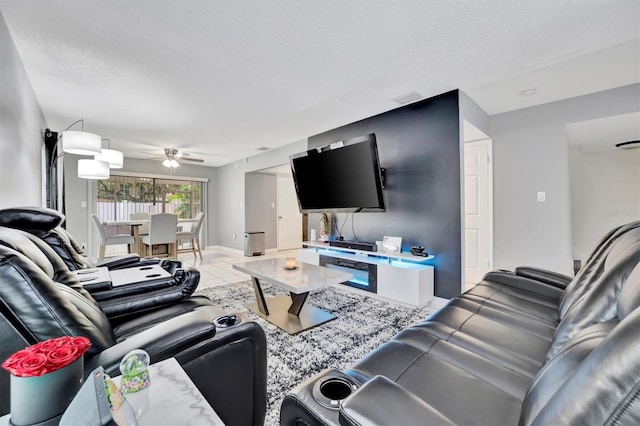 tiled living room featuring ceiling fan and a textured ceiling