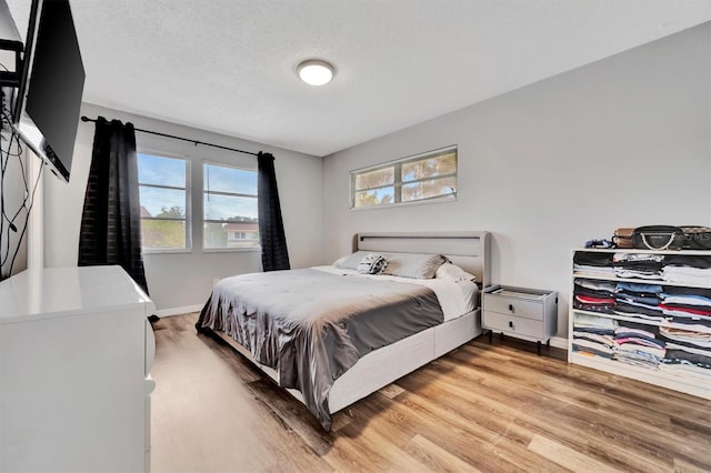 bedroom featuring wood-type flooring and a textured ceiling