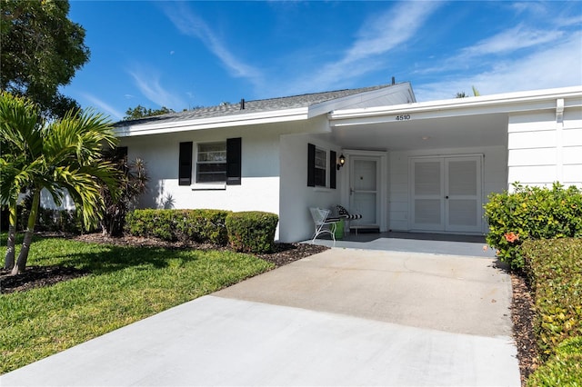 ranch-style house featuring a front yard and stucco siding